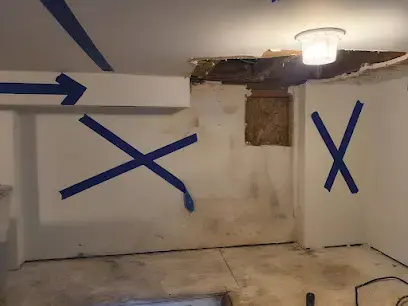 A wall marked with tape where moisture readings ran high, directly below an opened ceiling.