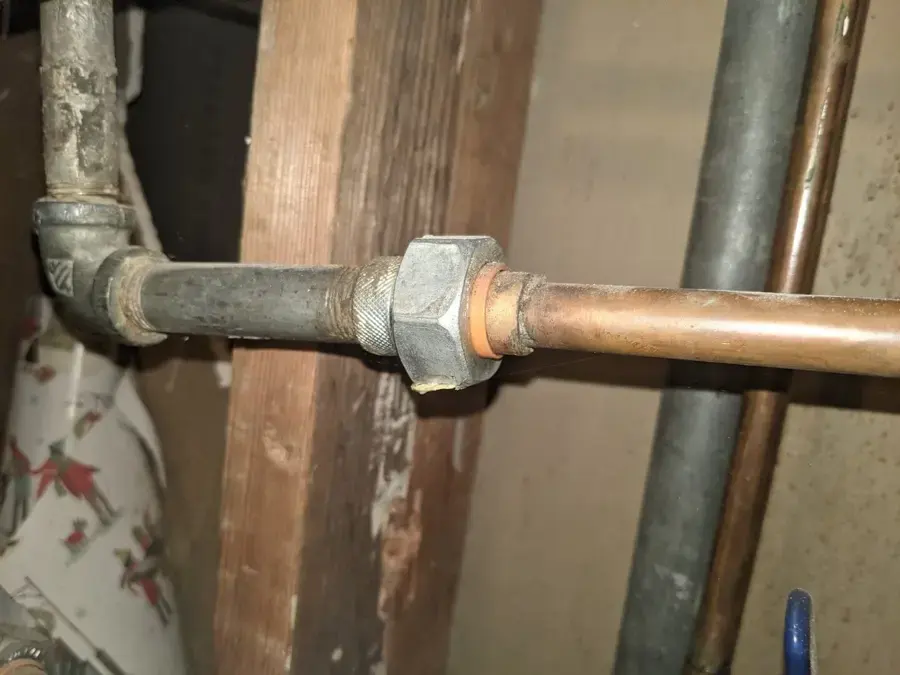 Galvanized steel pipe joined to copper supply pipe inside an opened wall, Granada Hills burst pipe water damage