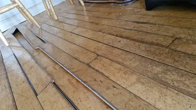 Hardwood boards cupped and lifted by water coming up from below, Granada Hills slab leak water damage