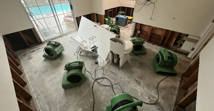 Air movers spread across a gutted room where the lower walls were cut open, Granada Hills structural drying